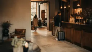 Gasten en medewerker in de lobby van een boutique hotel — warme sfeer, persoonlijk contact, vertrouwd gevoel.